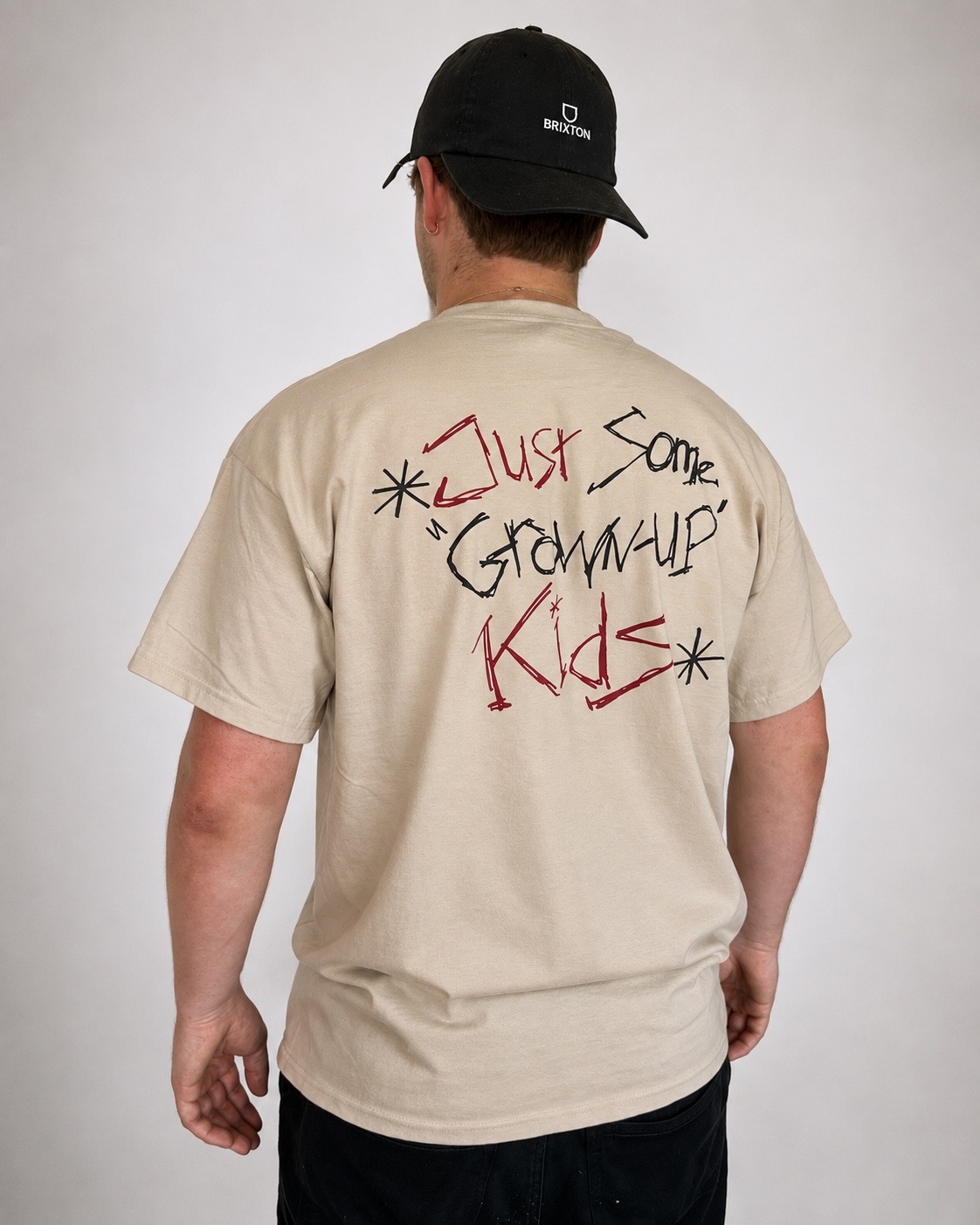 Just Some Grown-Up Kids t-shirt worn from the back, with the hand-drawn lettering across the upper back